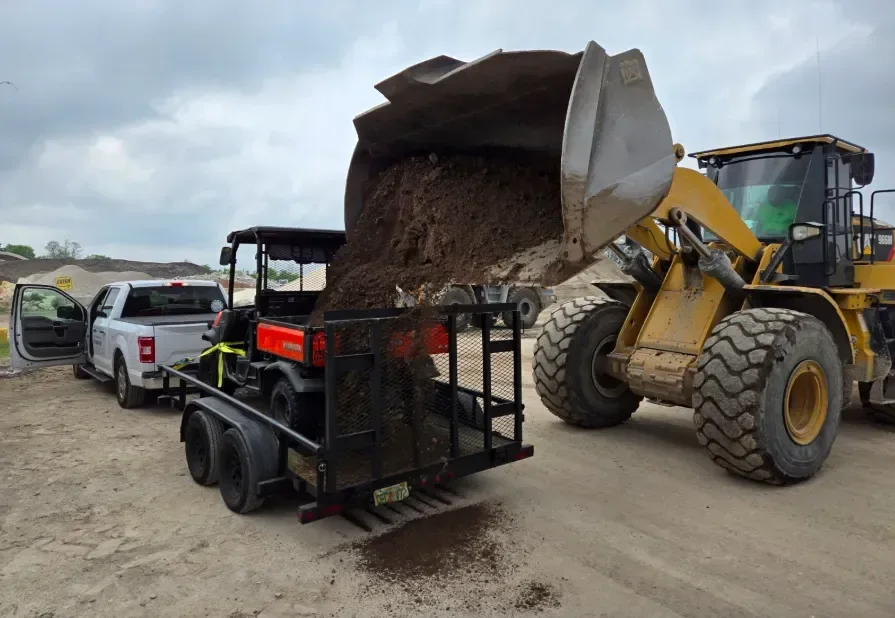 Loader filling a trailer with organic topsoil at PAW Materials in Odessa, FL