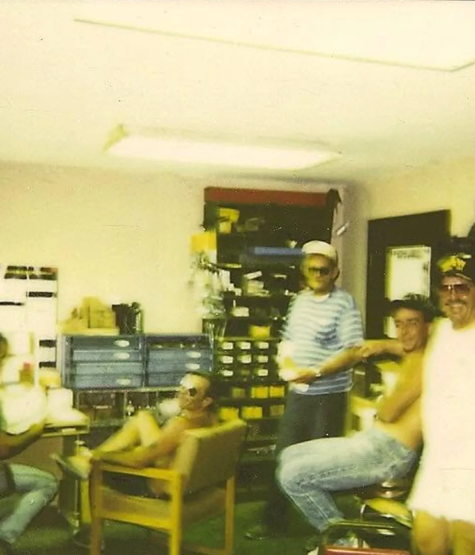 Early PAW crew gathered together in the shop office between jobs