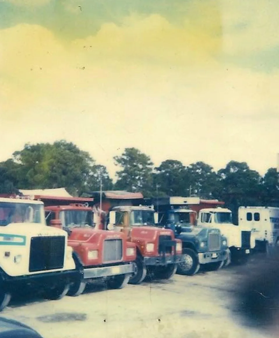 Early PAW fleet of dump trucks lined up side by side in the yard